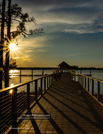 landscape photography of a sunburst over a waterfront gazebo pier