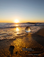 still life photography of a glass orb in the surf